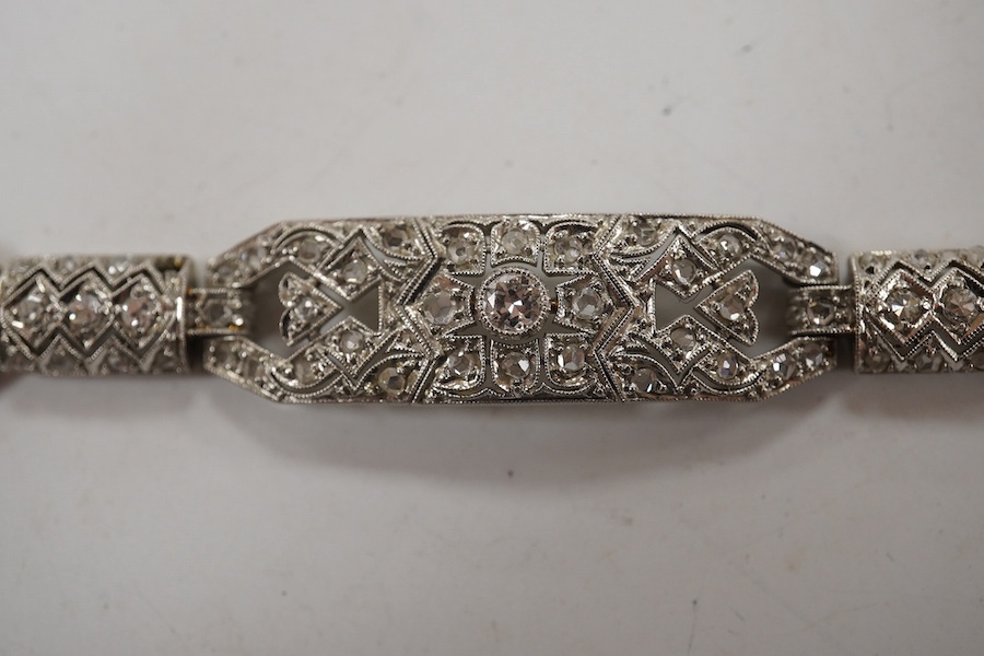 An early 20th century pierced white gold and millegrain set diamond cluster bracelet, set with round and rose cut stones, 18.1cm, gross weight 18.1 grams. Condition - fair to good
